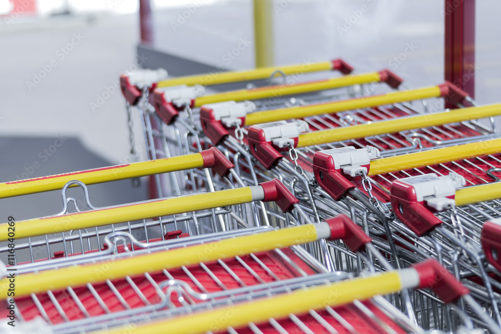 Collected in the number of shopping carts around a supermarket, red ,yellow,