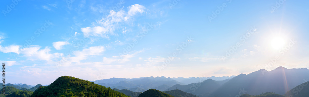 Panorama of sun flare with blue sky and mountains
