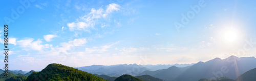 Panorama of sun flare with blue sky and mountains
