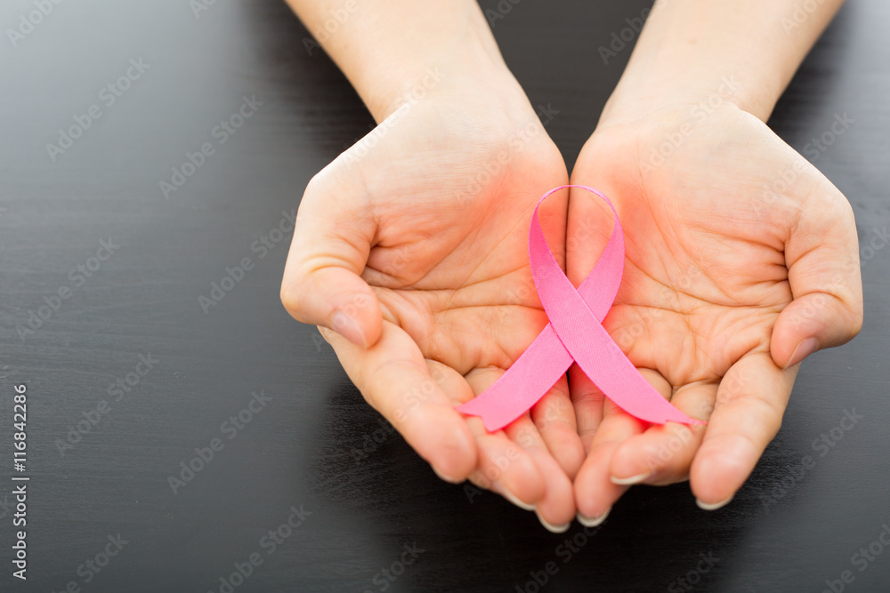 Pink Breast cancer awareness ribbon holding by woman