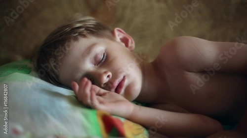 Little boy sleeping, in the dream his face muscles and body twitches, he dreams