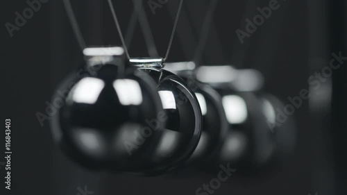 Slow motion shot of a Newton's Cradle.
