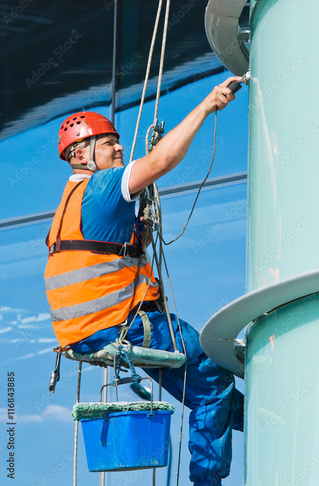 A man cleaning windows on a high rise building A man cleaning windows on a high rise building