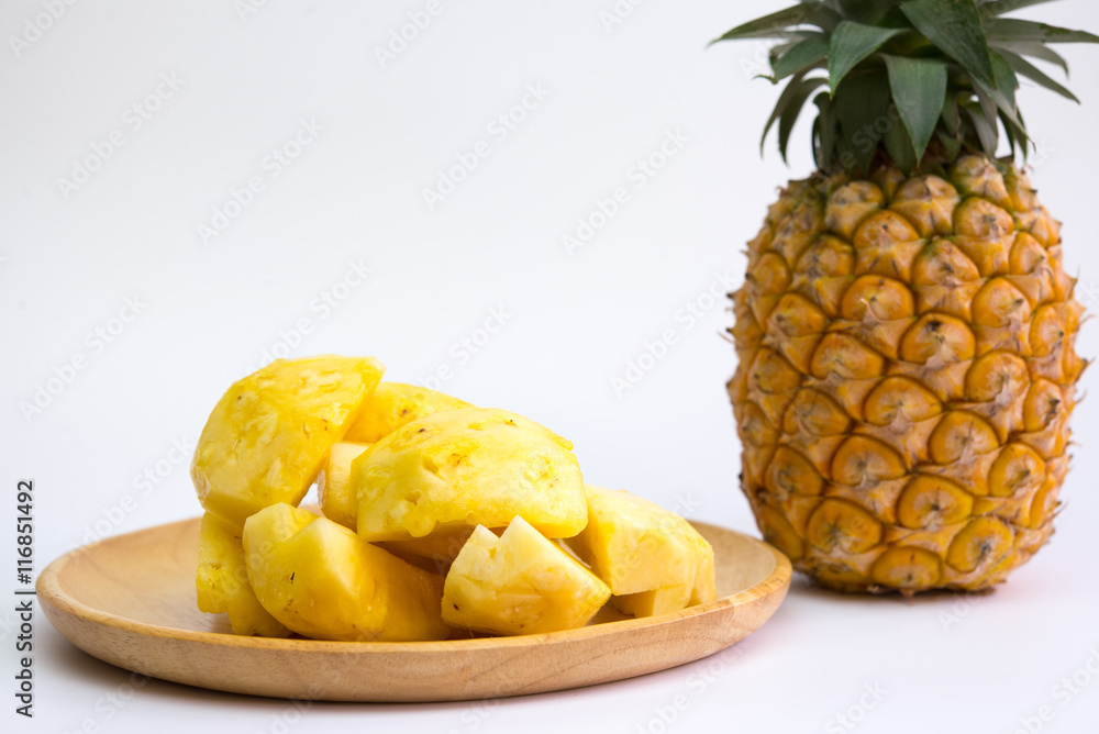 Pineapple fruit cut on wooden plate on white background Pineapple fruit cut on wooden plate on white background