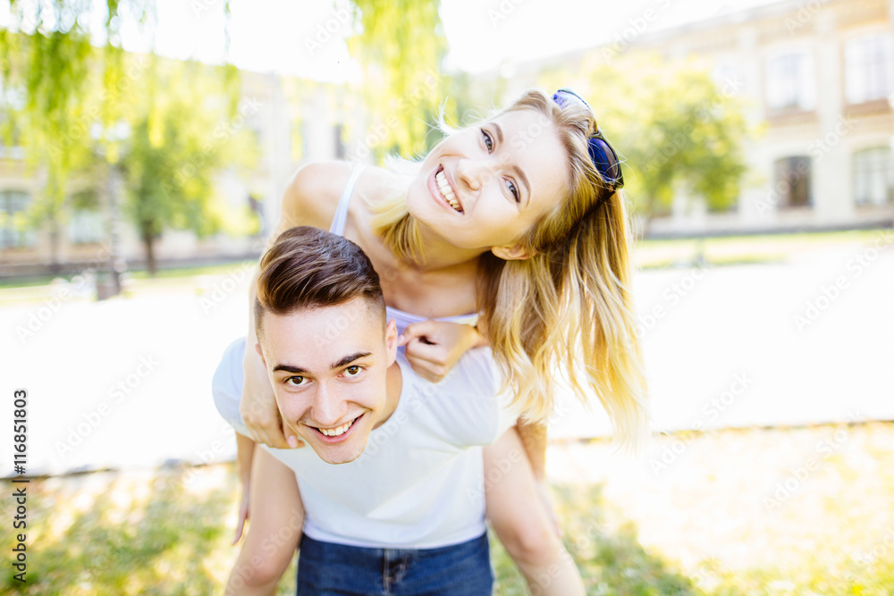 cheerful young couple having fun in the summer park cheerful young couple having fun in the summer park