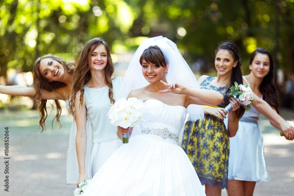Bride rises the sign of virctory posing with pretty bridesmaids Bride rises the sign of virctory posing with pretty bridesmaids