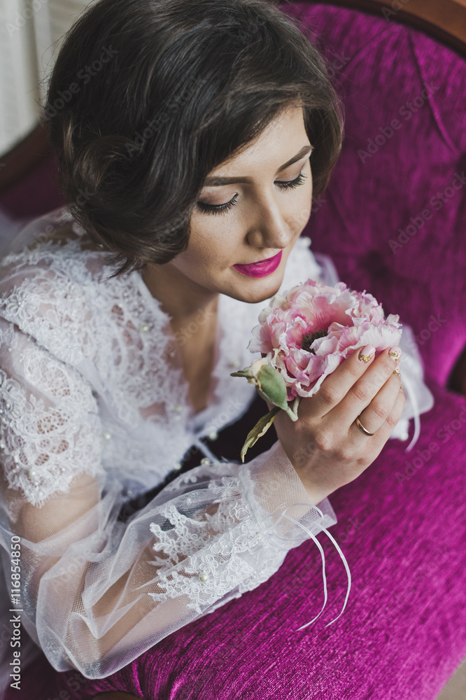 A beautiful girl in a dressing gown reclines on a purple sofa 63