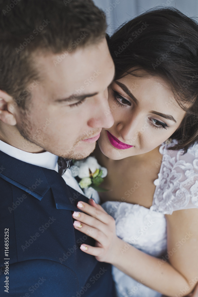 The young husband and wife gently kiss each other on the backgro The young husband and wife gently kiss each other on the backgro
