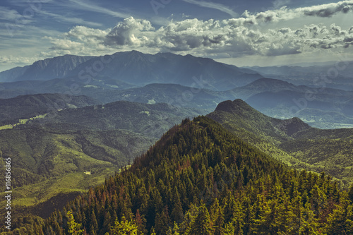 Beautiful panoramic scenery with Bucegi mountains range at the horizon, as seen from the Postavaru massif in Brasov county, Romania. Romanian travel destinations, touristic attractions.