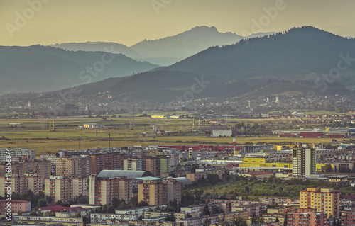 Early morning aerial cityscape of residential districts and suburbs of the Brasov city, the 7th largest city and most visited in Romania.