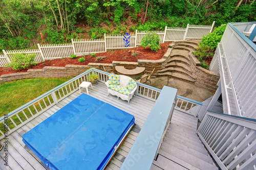 Two level backyard deck with jacuzzi on the first floor and patio area on the second one