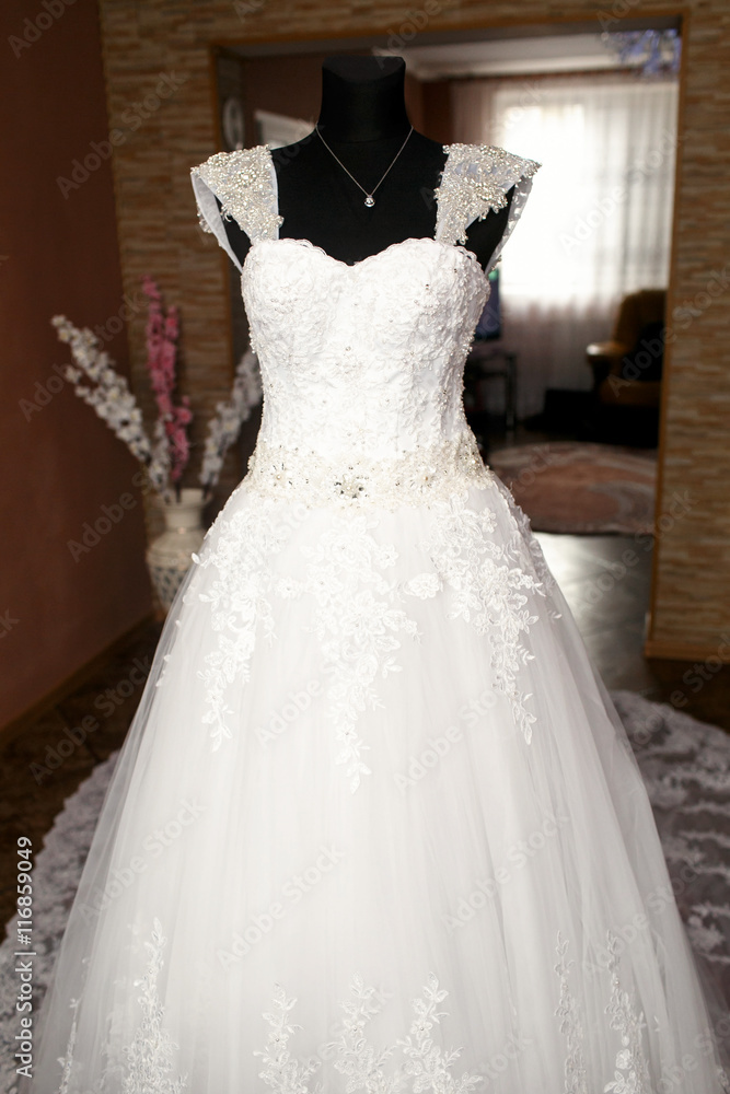 The wedding dress stands near room The wedding dress stands near room