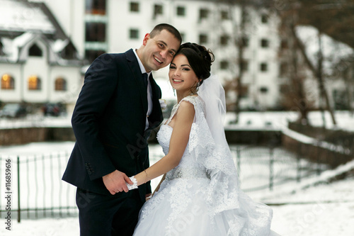 The brides embrace near frozen lake