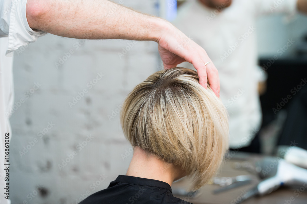 Closeup back view of teen young girl woman sitting in chair in hair salon  looking in mirror while hairdresser checking her new haircut Stock Photo |  Adobe Stock