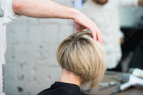 Print op canvas Closeup back view of teen young girl woman sitting in chair in hair salon lookin