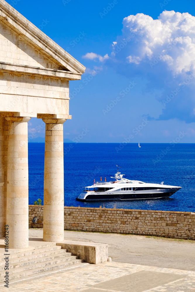 Greek symbol Pantheon near the sea with yacht. Typical Greece co