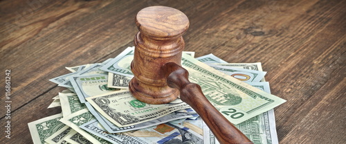 Stack Of Banknotes With Judges Or Auctioneers Gavel Or Hammer photo