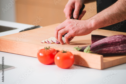 Closeup man's hands cutting vegetables in a kitchen