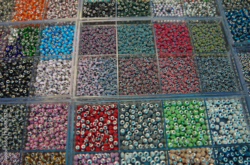 Hundreds of multi color beads in clear plastic boxes