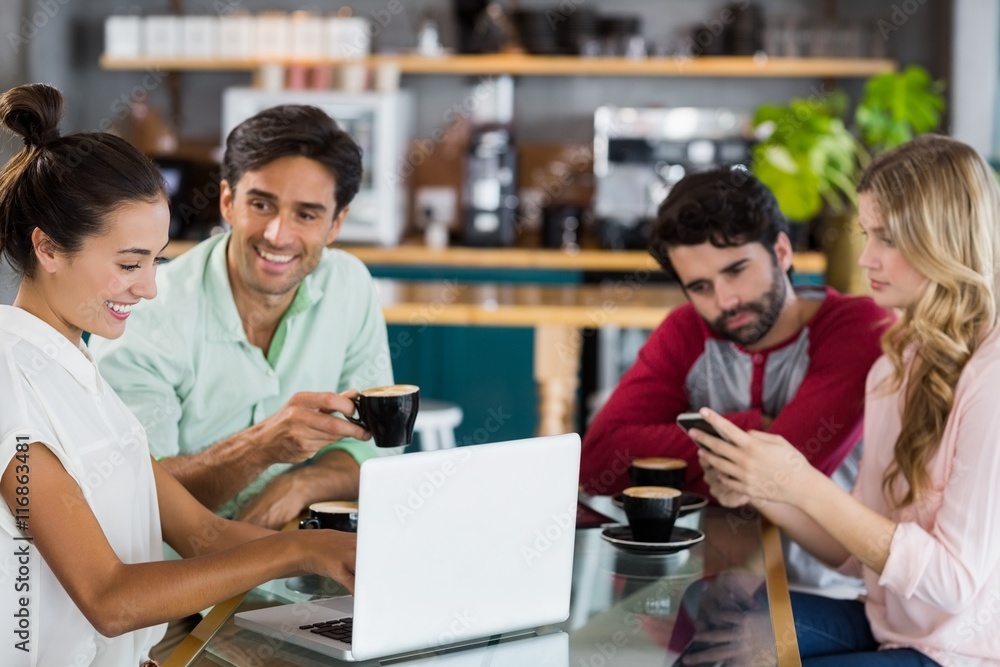 Group of friends using mobile phone and laptop Group of friends using mobile phone and laptop