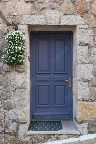 Old wooden door in the entrance stone French house