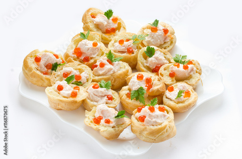 Profiteroles with mousse or pate and red caviar on white background