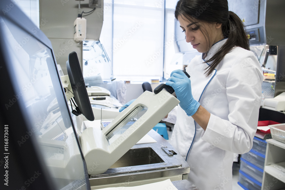 Laboratory technician in analytical laboratory using a cytology scanner Laboratory technician in analytical laboratory using a cytology scanner