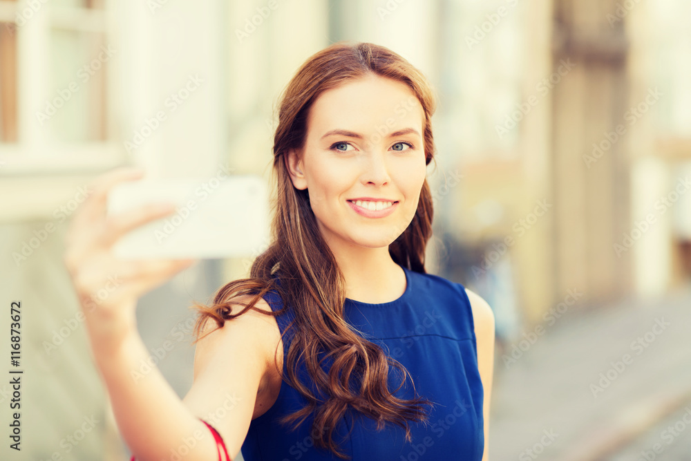 happy woman taking selfie with smartphone in city