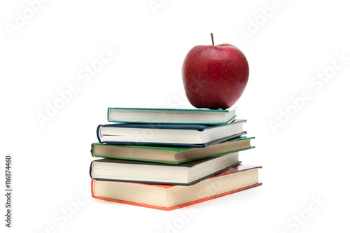 stack of books and red apple on a white background
