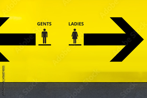 Restroom or Toilet Sign with Arrow on Yellow Wall