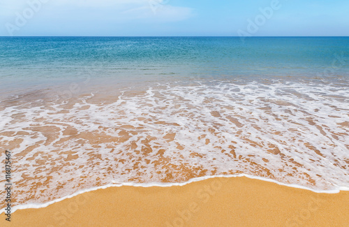 white soft wave on tropical beach and blue sky background