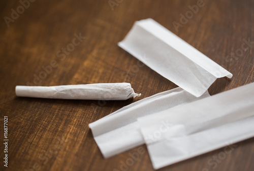 close up of marijuana joint and cigarette paper photo