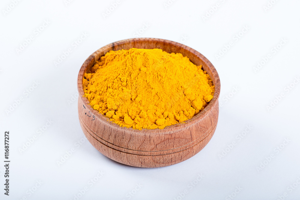 Curcuma in a wooden bowl isolated on white background Curcuma in a wooden bowl isolated on white background