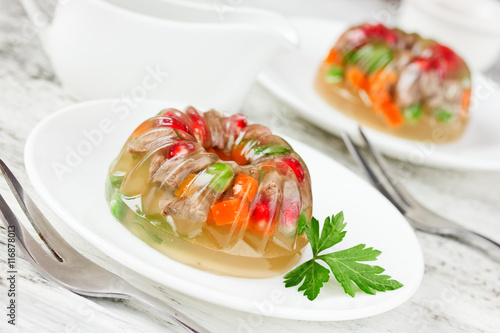Aspic decorated with pomegranate, green peas, carrot and parsley