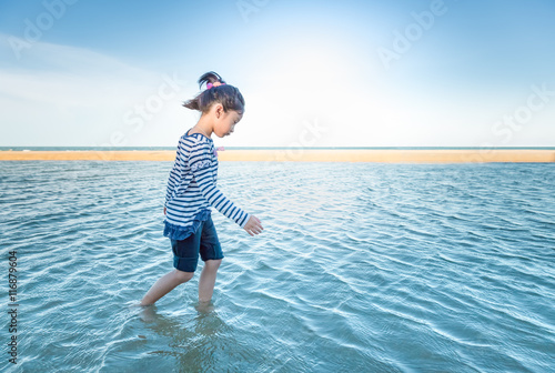 Little asian girl feeling relax on the beach, Concept of little girl freedom walking on the beach.