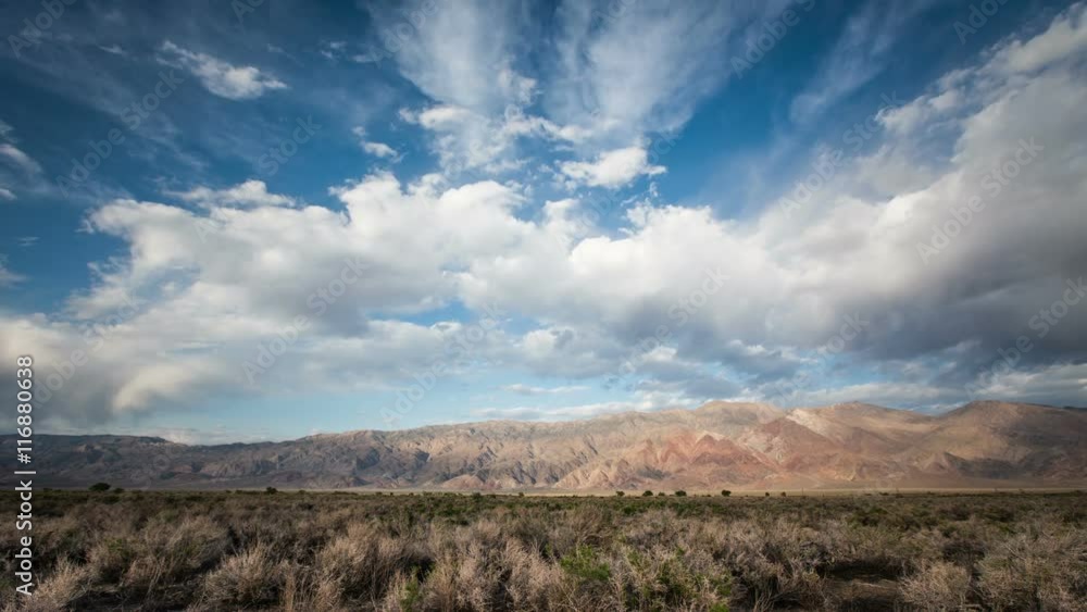 Time-Lapse of big puffy clouds over a desert mountain range. Time-Lapse of big puffy clouds over a desert mountain range.