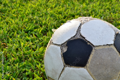 Close-up of old football on the lawn in evening day,sport equipment.