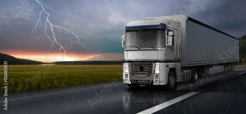 Photos The white truck travels on the road in the rain.