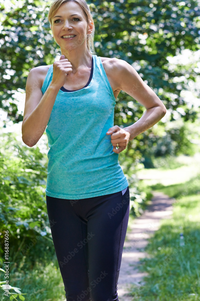 Mature Woman Running Outdoors In Countryside Mature Woman Running Outdoors In Countryside