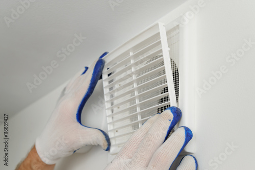 Foto Worker installs ventilation grille.