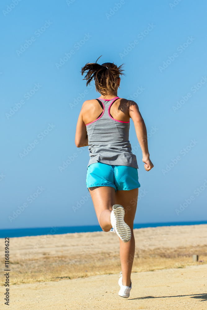 Full length rear view of female athlete running. Full length rear view of female athlete running.