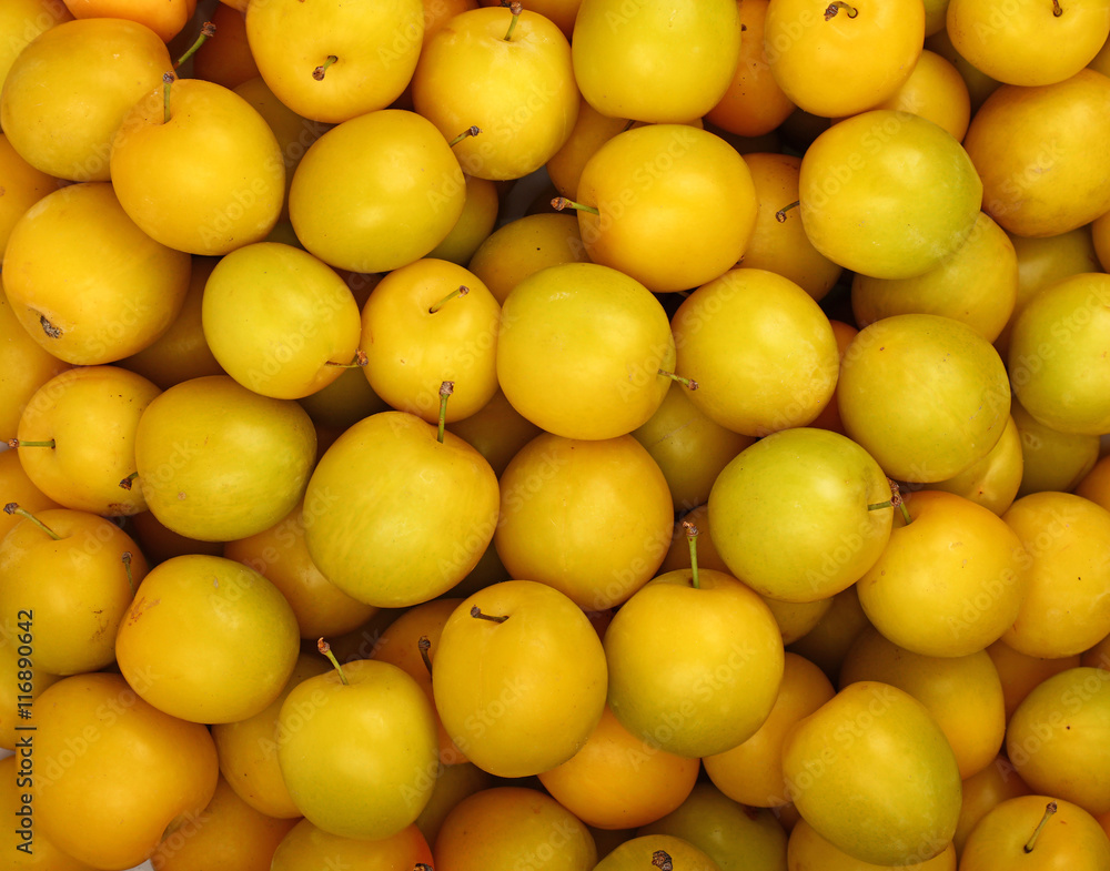 Background of fresh yellow plums close up