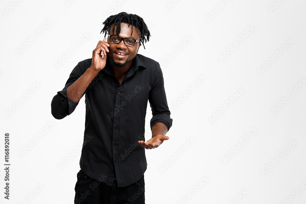 Young successful african businessman speaking on phone over white background. Young successful african businessman speaking on phone over white background.
