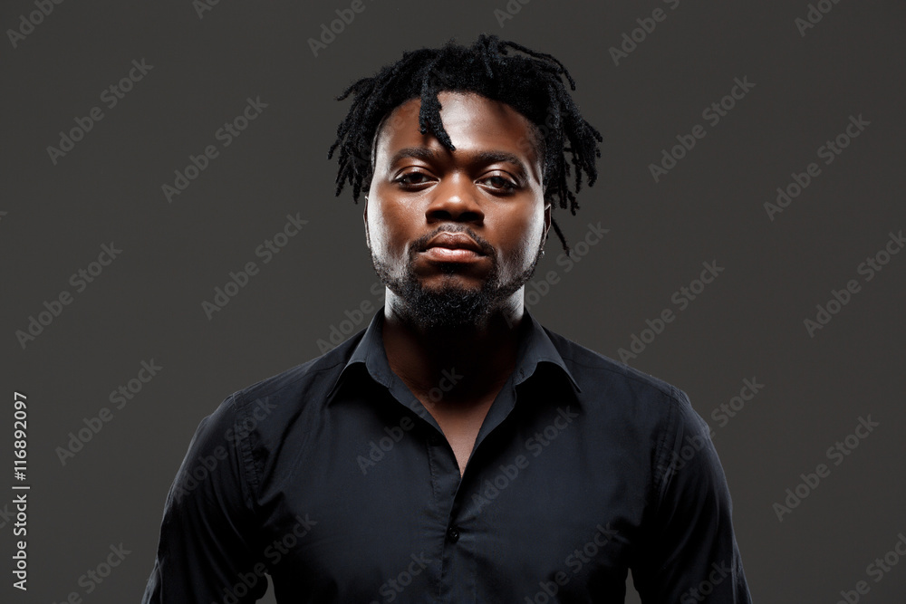 Young successful african businessman posing over dark background. Young successful african businessman posing over dark background.