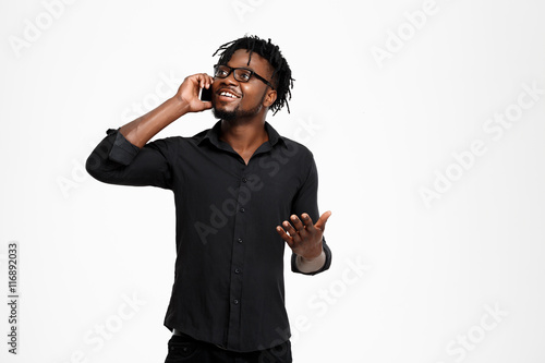 Cuadro en lienzo Young successful african businessman speaking on phone over white background