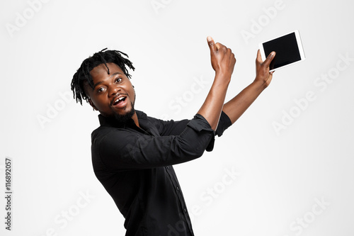 Young successful african businessman making selfie over white background.