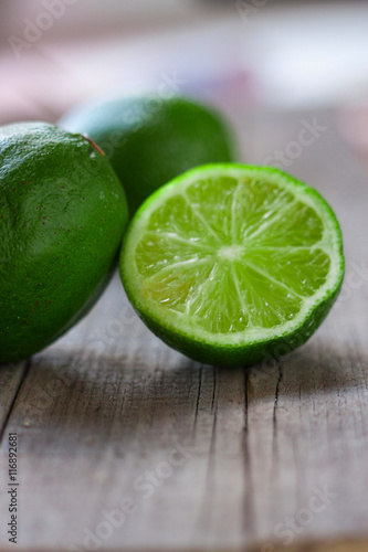 limes with half on a wooden background