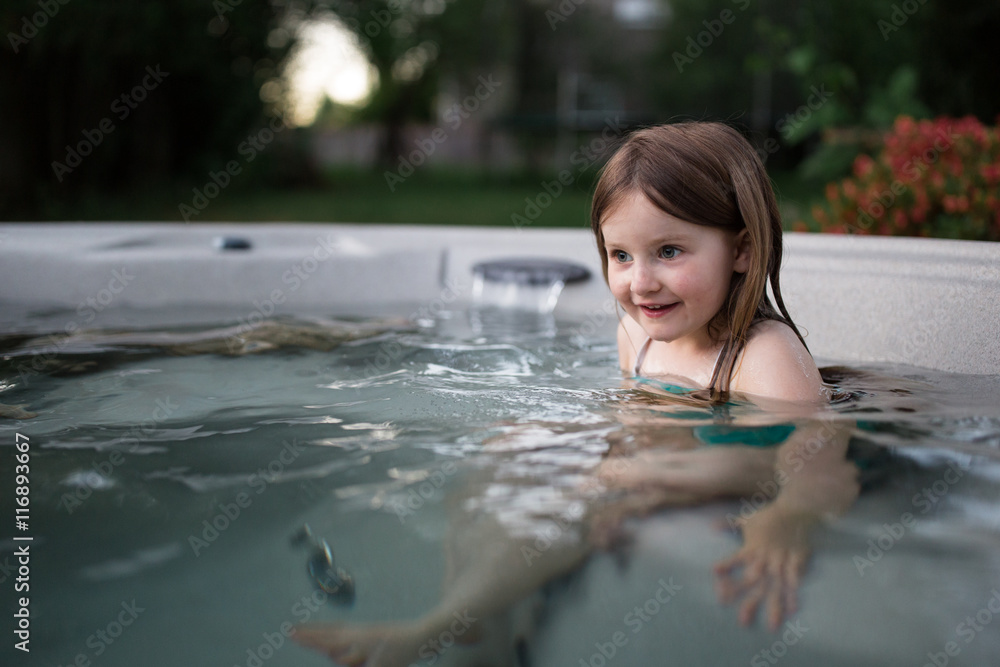 Small girl sitting in hot tub full of water Photos | Adobe Stock