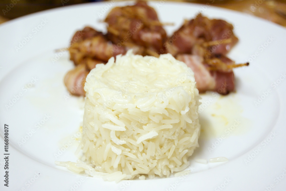 Rice with Rolls of slices of cooked bacon subject with a toothpi Rice with Rolls of slices of cooked bacon subject with a toothpi