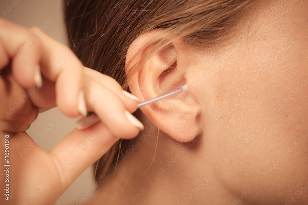 Woman cleaning ear with cotton swabs closeup Woman cleaning ear with cotton swabs closeup
